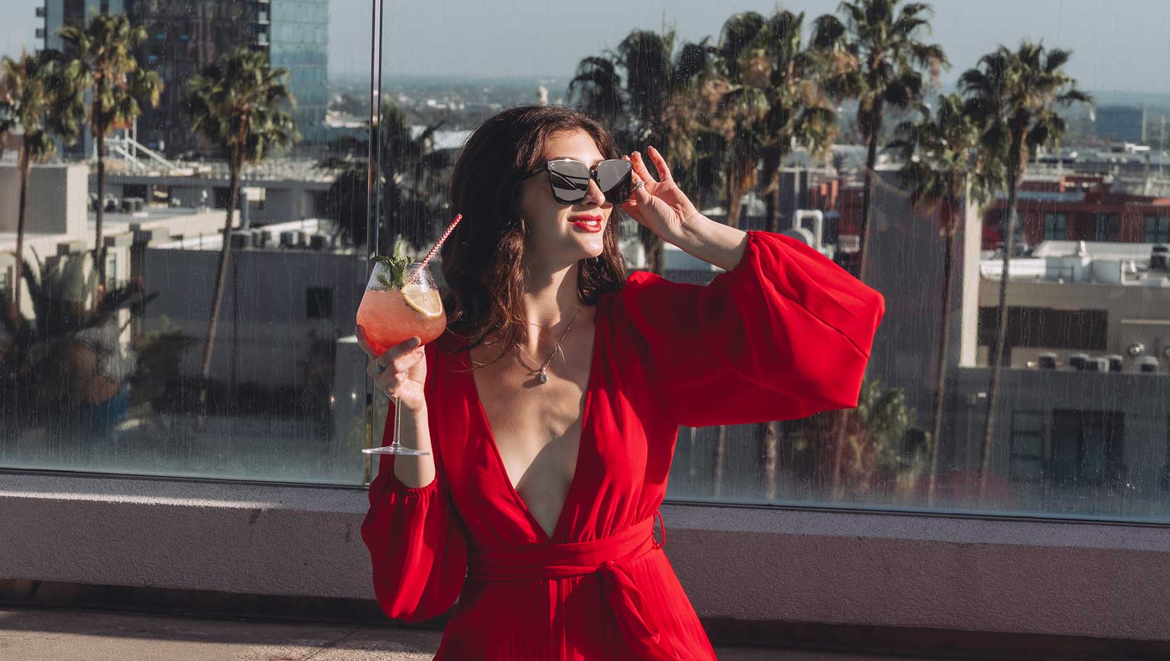 Woman with cocktail at The Scene Rooftop Pool at Kimpton Everly Hotel