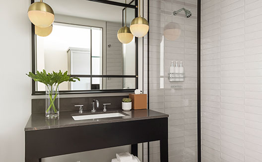 Suite bathroom sink and shower at Kimpton Everly Hotel