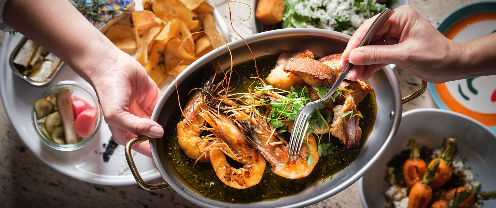 Written hand shrimp dish with other food items in the background